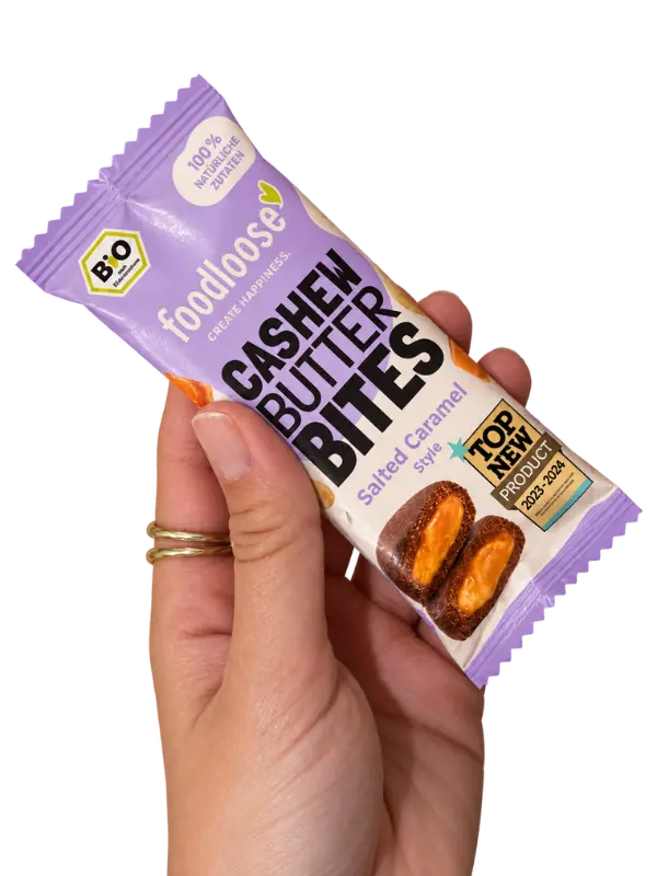 Hand mit Packung Cashew Butter Bites